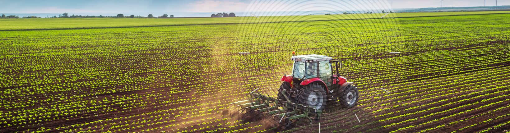 Photograph of tractor in a field with concentric signal rings emanating from it